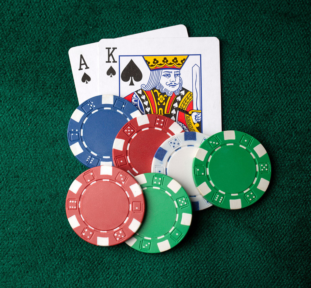 Ace of spades, king of spades, and a stack of poker chips on the table.